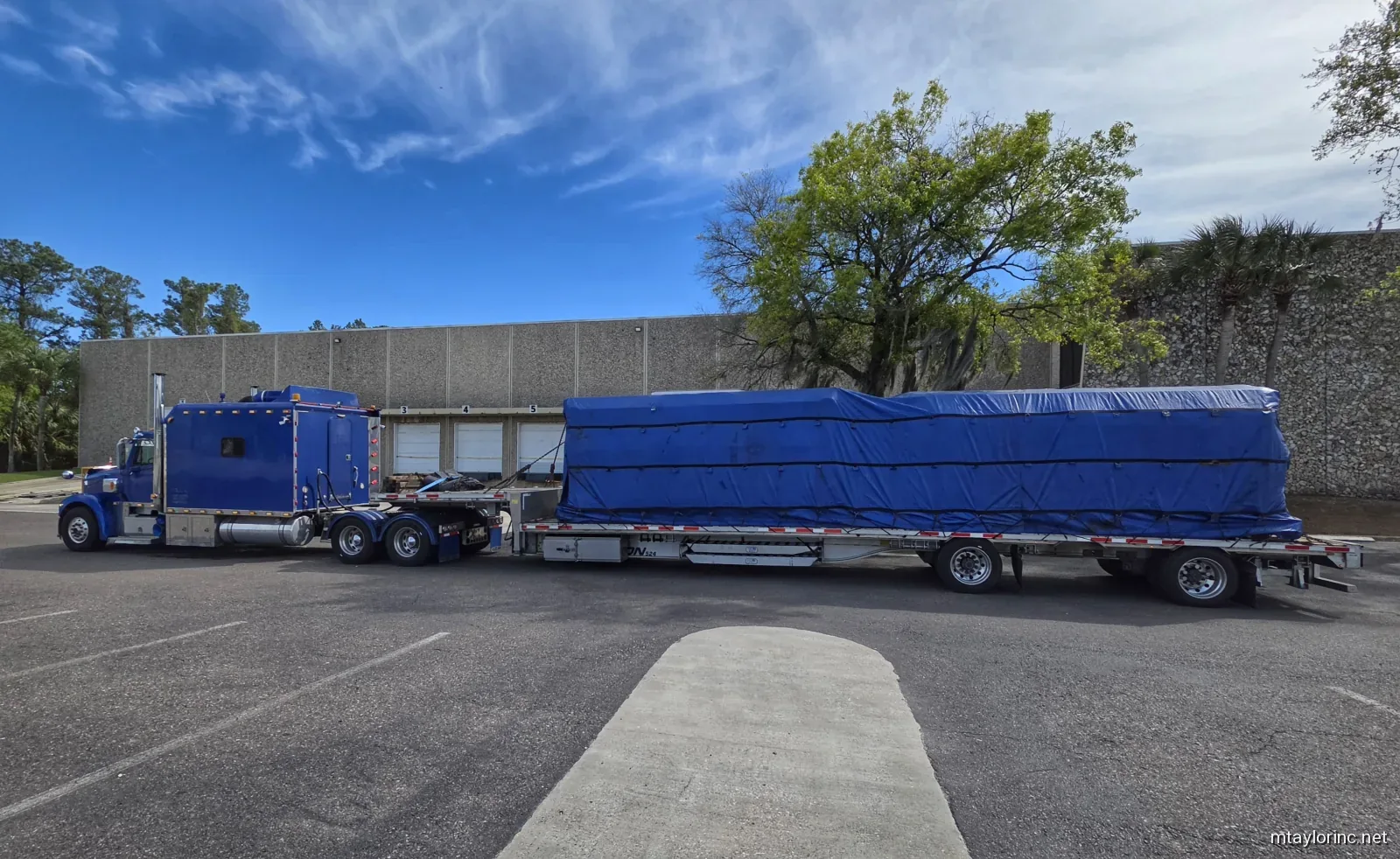 M Taylor Inc stepdeck hauling tarped high-value electrical equipment from Florida to a Georgia power substation